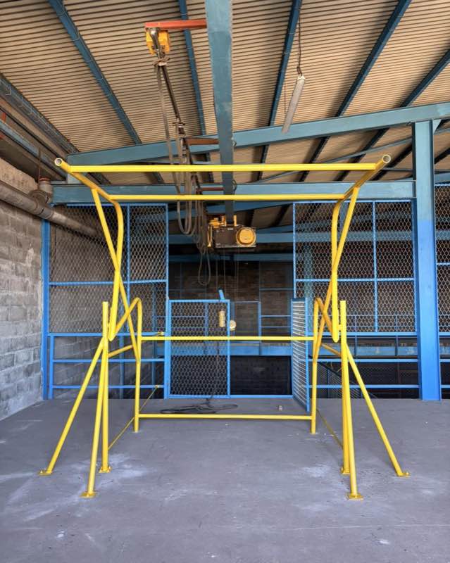 Sas à palettes en acier jaune installé en bord de mezzanine, vu de face