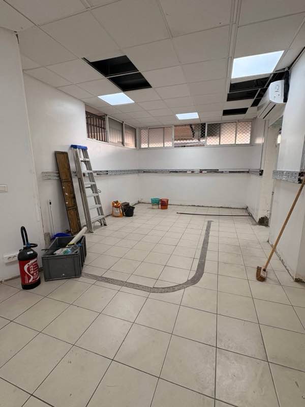 Le local avant travaux : ancien carrelage et saignée réalisée dans le sol
